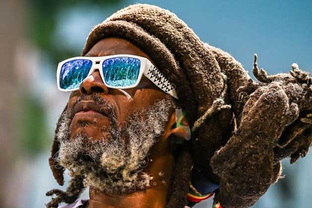 IRE115-polarized-irie-bomb-mana-steel-pulse-reggae-legend Irie Bombs de espejo rojo con marcos negros que muestran el reflejo de una puesta de sol de Guatemala en las lentes